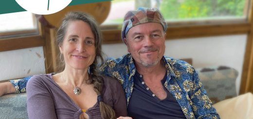Simone und Heinz Feldmann sitzen auf einem Sofa und halten das Buch "Leben in Gemeinschaft" in die Kamera