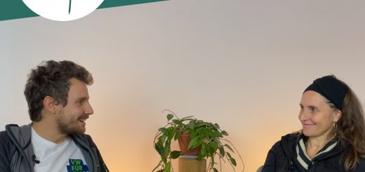 Tobi Rosswog und Simone Britsch sitzen sich gegenüber uns lächelns sich an