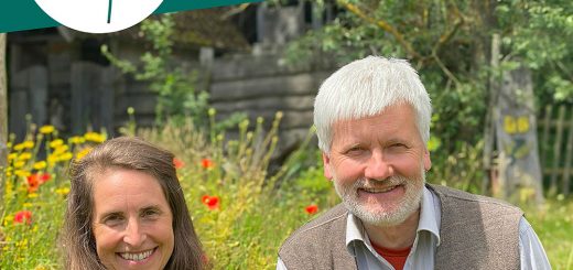 Simone und Dieter stehen vor einer blühenden Wiese und schauen freundlich in die Kamera