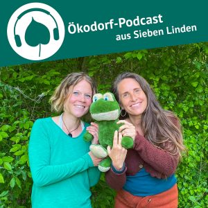 Aniko und Simone stehen vor einer grünen Hecke und halten einen Stofftierfrosch in ihrer Mitte.